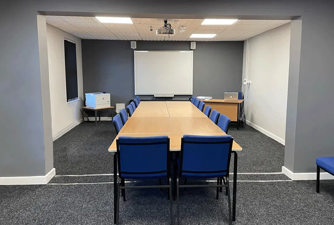 Photo showing long view of the main conference room, showing the presentation end