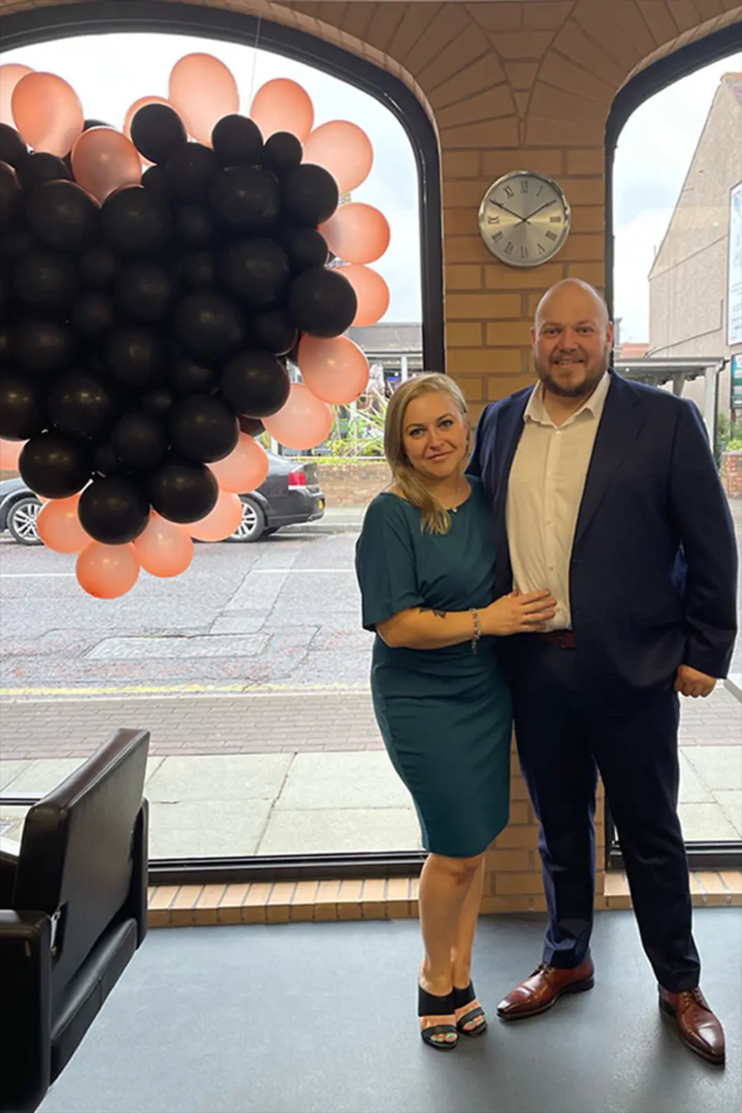 Photo showing Carol and Chris standing in front of a balloon version of the black heart